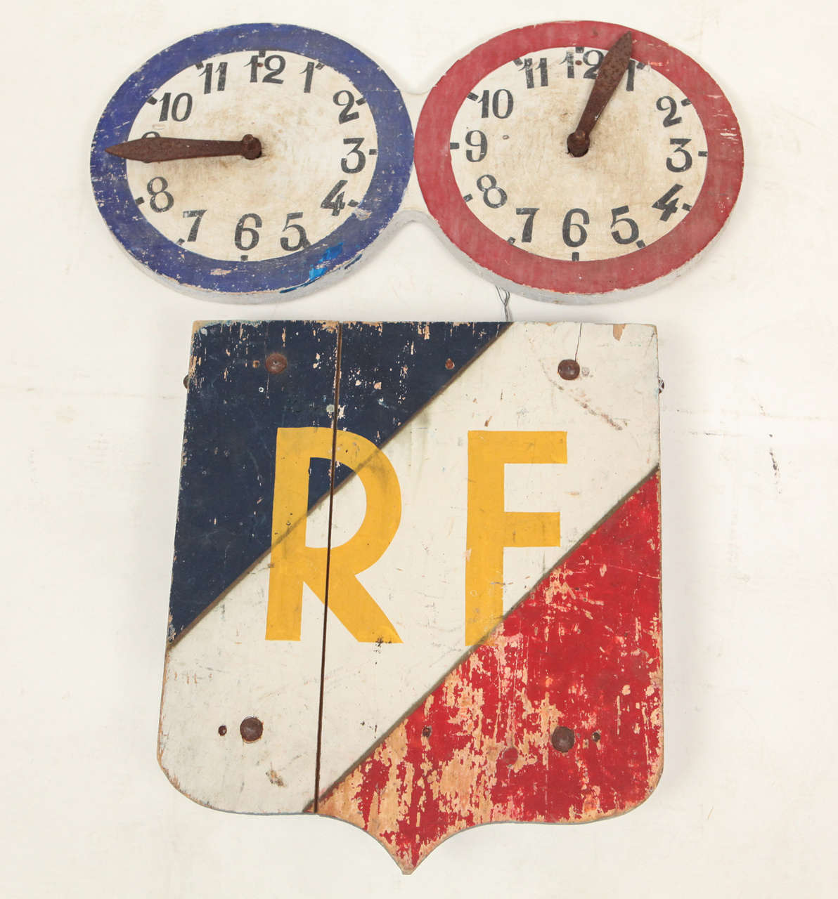 Two vintage wood and wrought iron French signs from the early 20th Century. One has the RF monogram (Republique Francais) and the other are two clocks each with only one stem. Probably to signify opening hour and closing hour.

RF sign is 16 w x