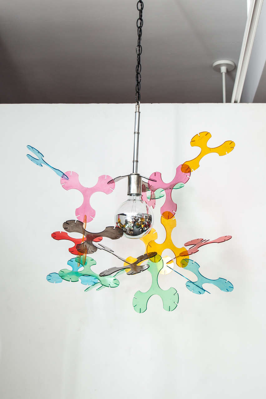 A chrome light fixture with suspended multicolor Lucite forms.  USA, circa 1980.

Wired for U.S.; takes a standard base bulb, 100 watts max.