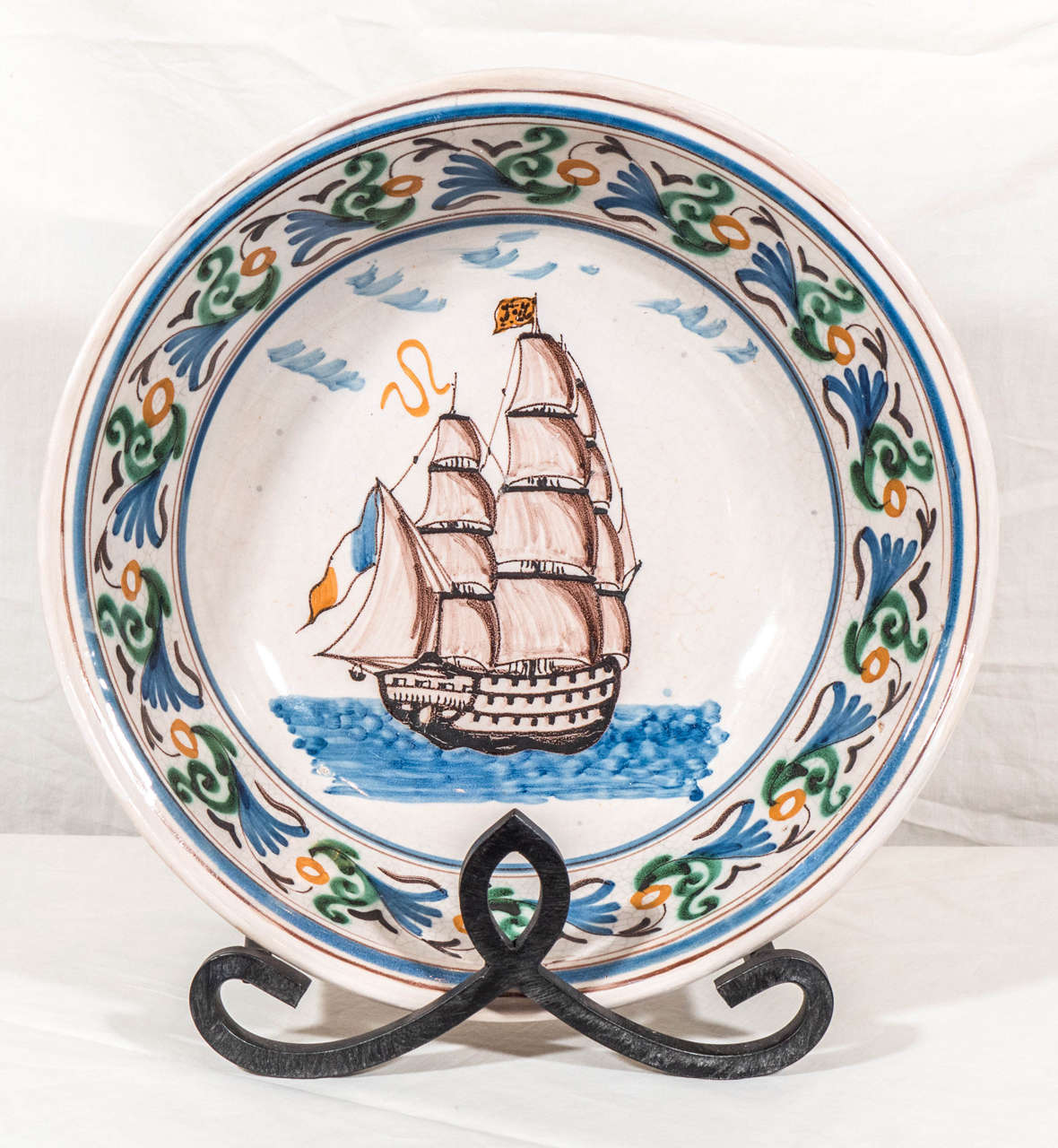 We are pleased to offer this large faience bowl featuring a three masted three-decker ship. The ship is under full sail, moving ahead rapidly on wavy blue waters. This attractive scene is simple yet majestic; relying on only three colors: the shades