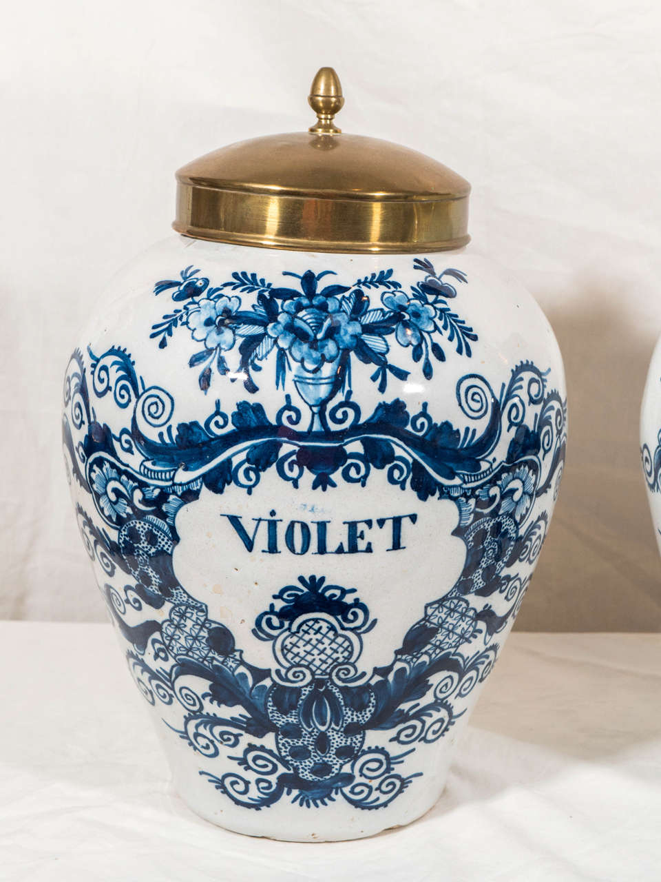 A pair of 18th century Dutch delft tobacco jars of ovoid form decorated in blue and white with the inscriptions 
