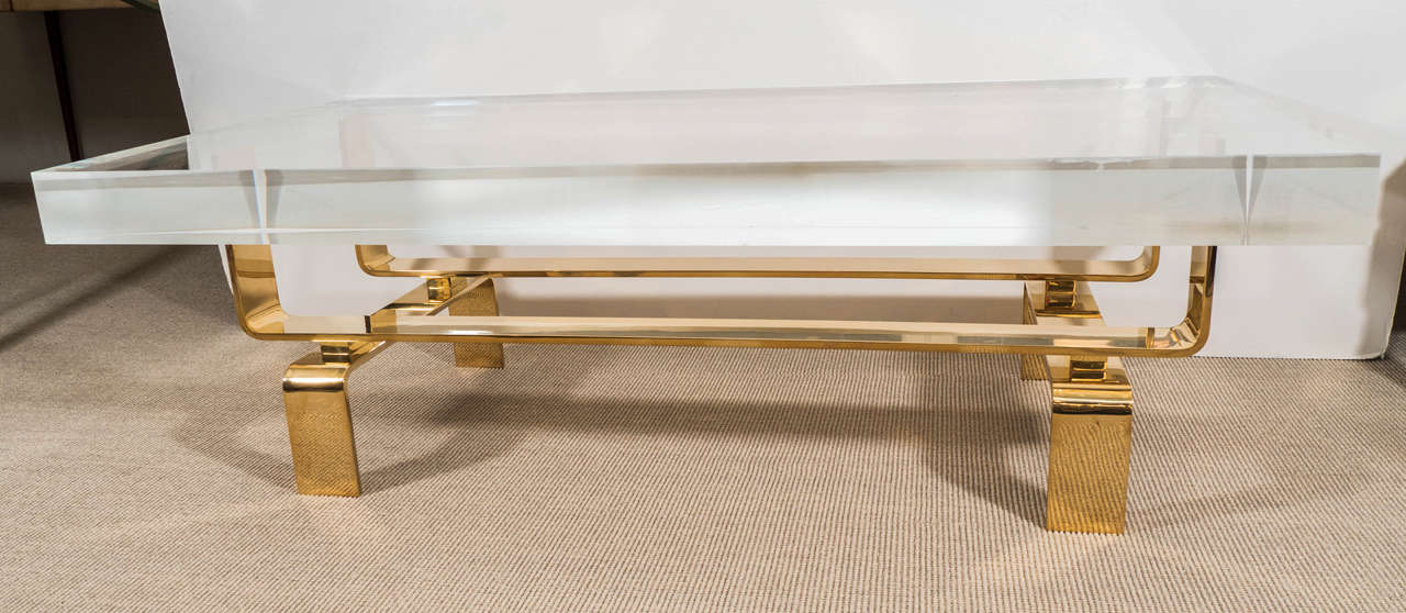 A limited edition Lucite and mirror polished bronze custom designed made to order cocktail table.

Lucite top, bent/cast bronze base.