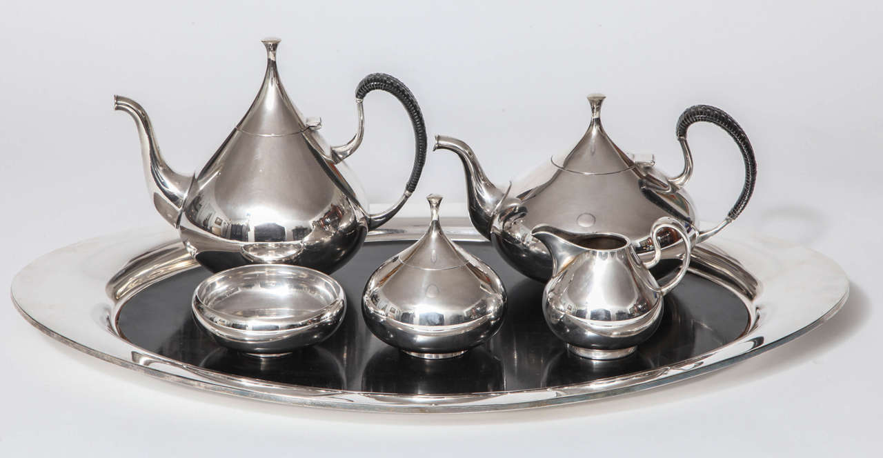 A complete tea and coffee service in silver plate with original laminate tray insert, designed by John Prip for Reed and Barton. Mint condition. The set is in the Dallas museum collection and is illustrated in Modernism in American Silver 20th