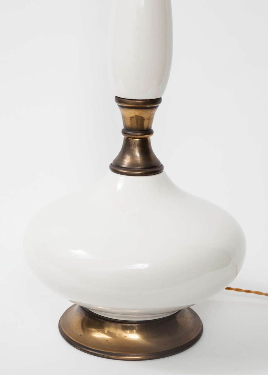 Pair of white ceramic and antique brass table lamps with a graceful Genie Bottle form. USA, circa 1960.  May be viewed at the 1stdibs showroom at the New York Design Center.

Dimensions:
Height (overall): 28 inches.
Height (from base to socket): 25