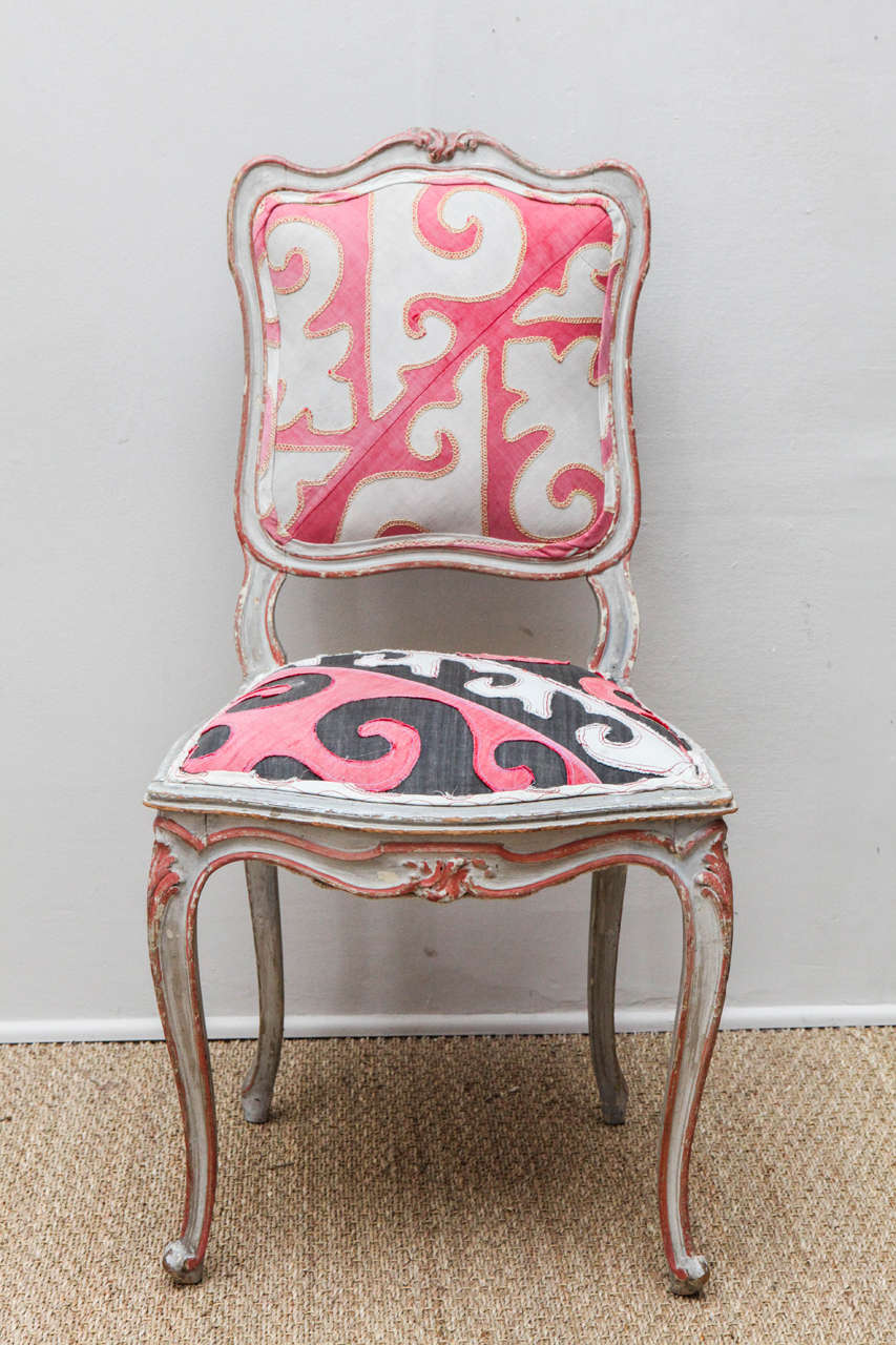Distressed pink and white painted French chairs,  Finish is distressed but chairs have been refurbished and are sturdy.  Newly upholstered with Central Asian appliquéd cotton tent trapping.  May be purchased individually.