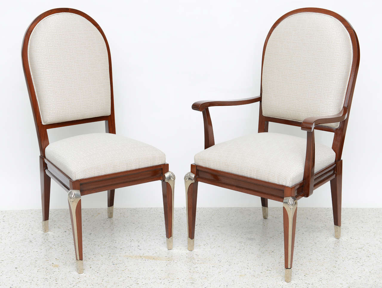 The set consisting of two arms and six sides, the oval backs with drop in seat over legs with fine silvered bronze mounts.