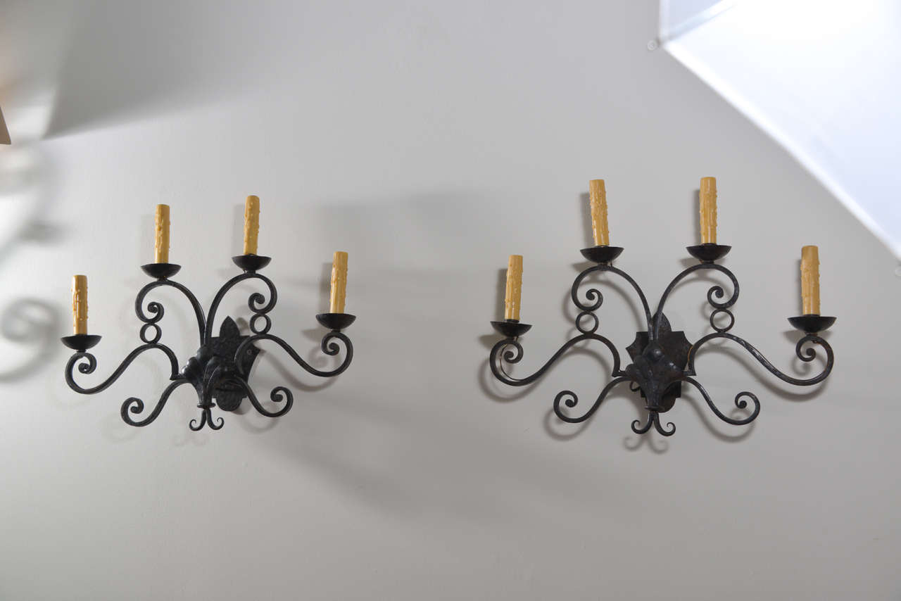 Pair of 19th century rewired iron sconces with four candle arms on each sconce.