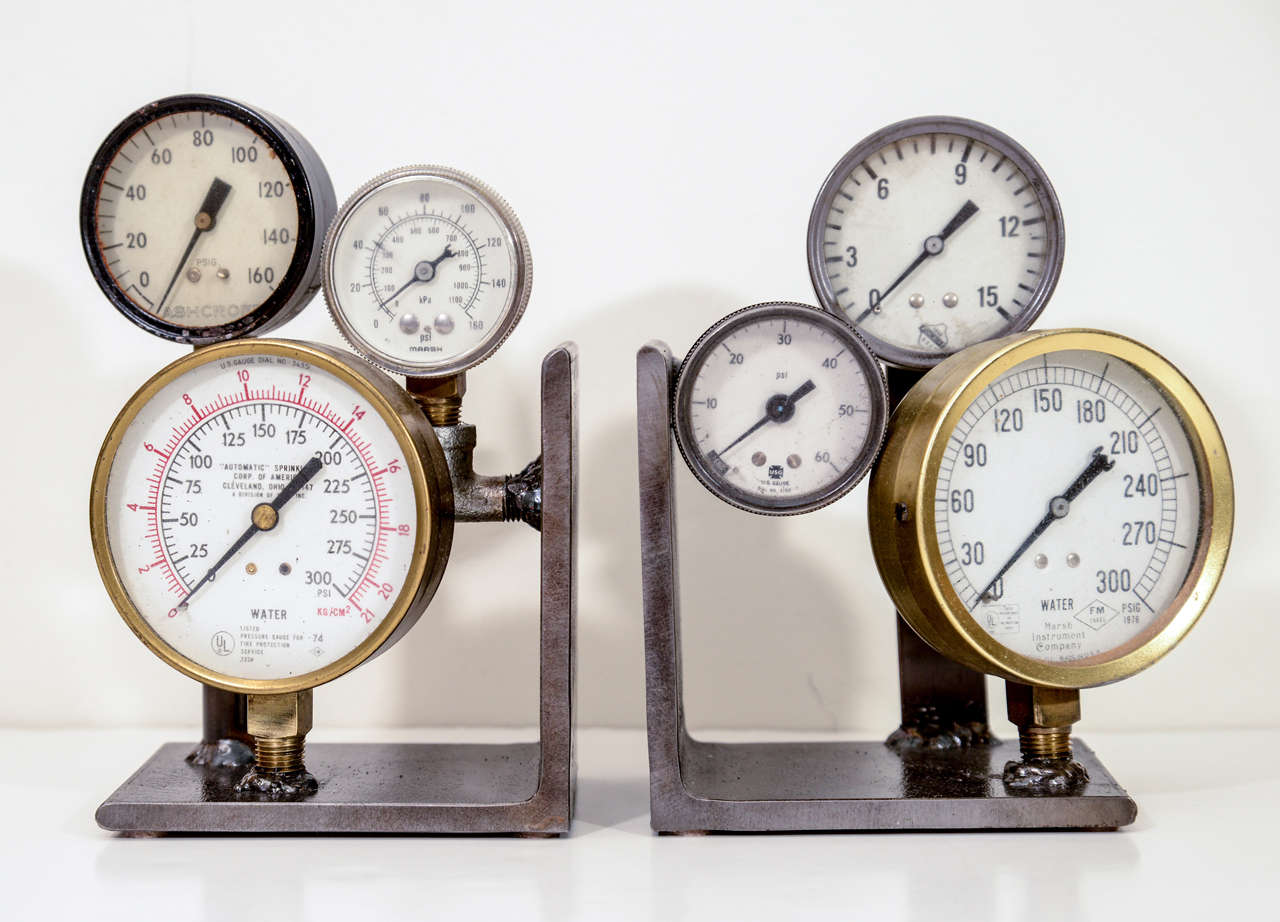 Pair of custom made bookends composed of vintage industrial pressure gauges on steel bases.