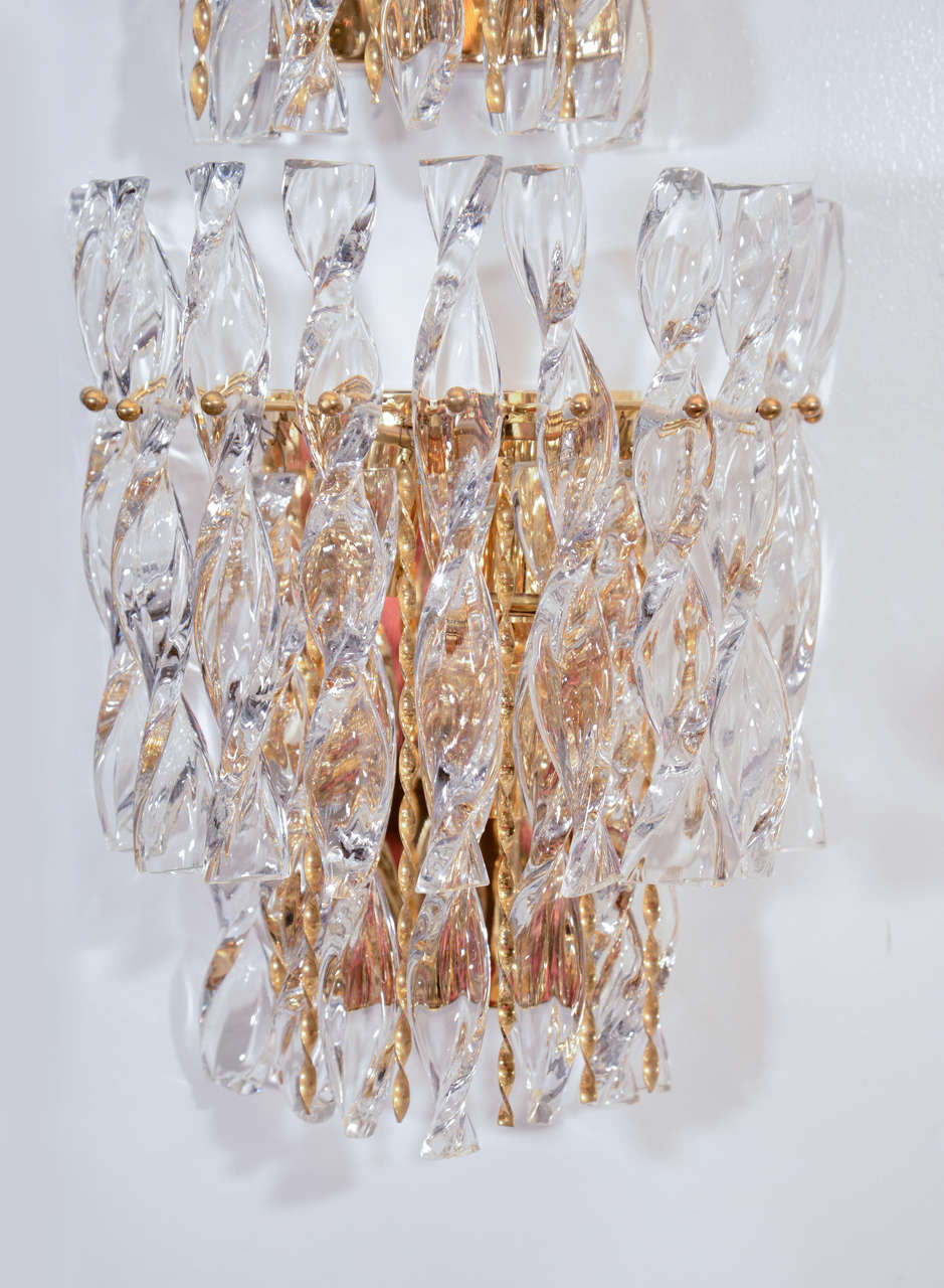 Fantastic wall sconces composed of spiral crystal elements and 22kt gilt washed brass pieces on a 22kt gilt washed backplate by Palwa. 1 pair and a single for sale.