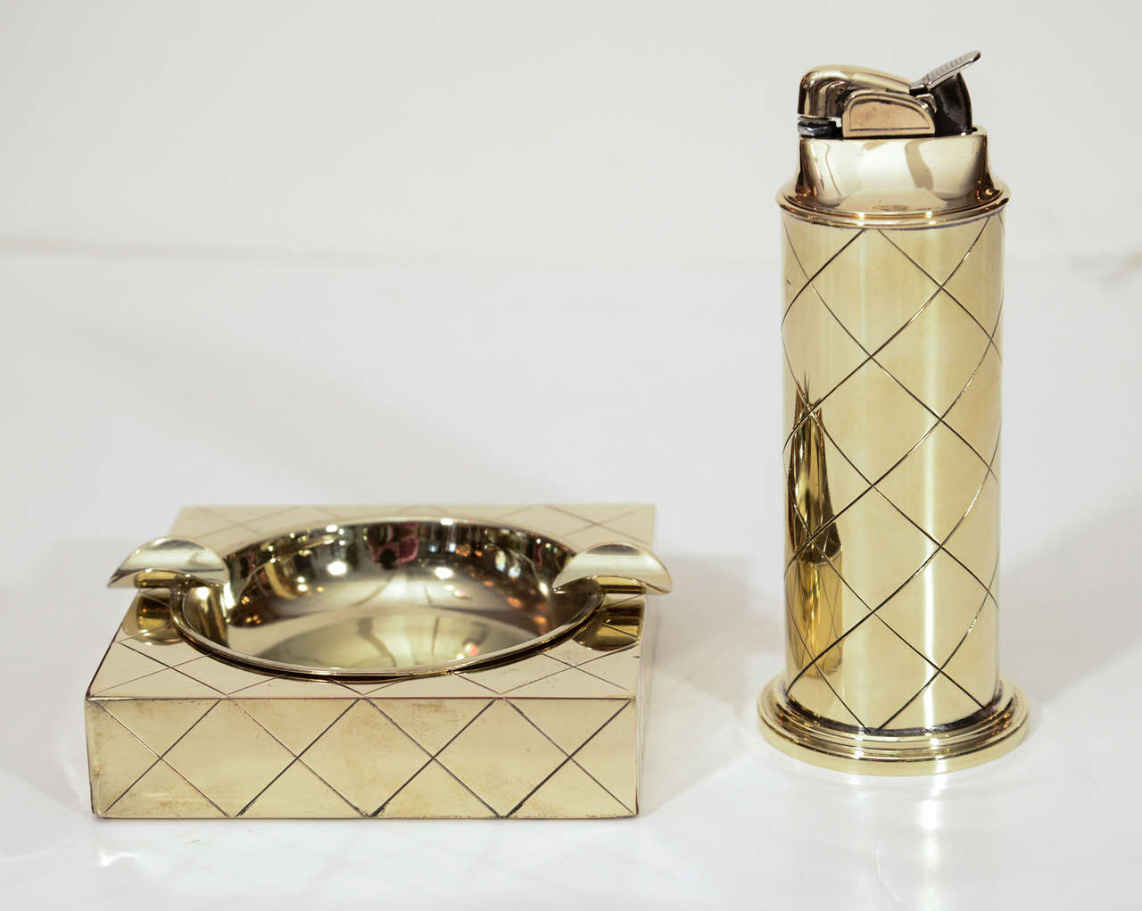 Fantastic rare brass smoking set composed of a lighter and ashtray featuring the iconic diamond pattern by Tommi Parzinger.