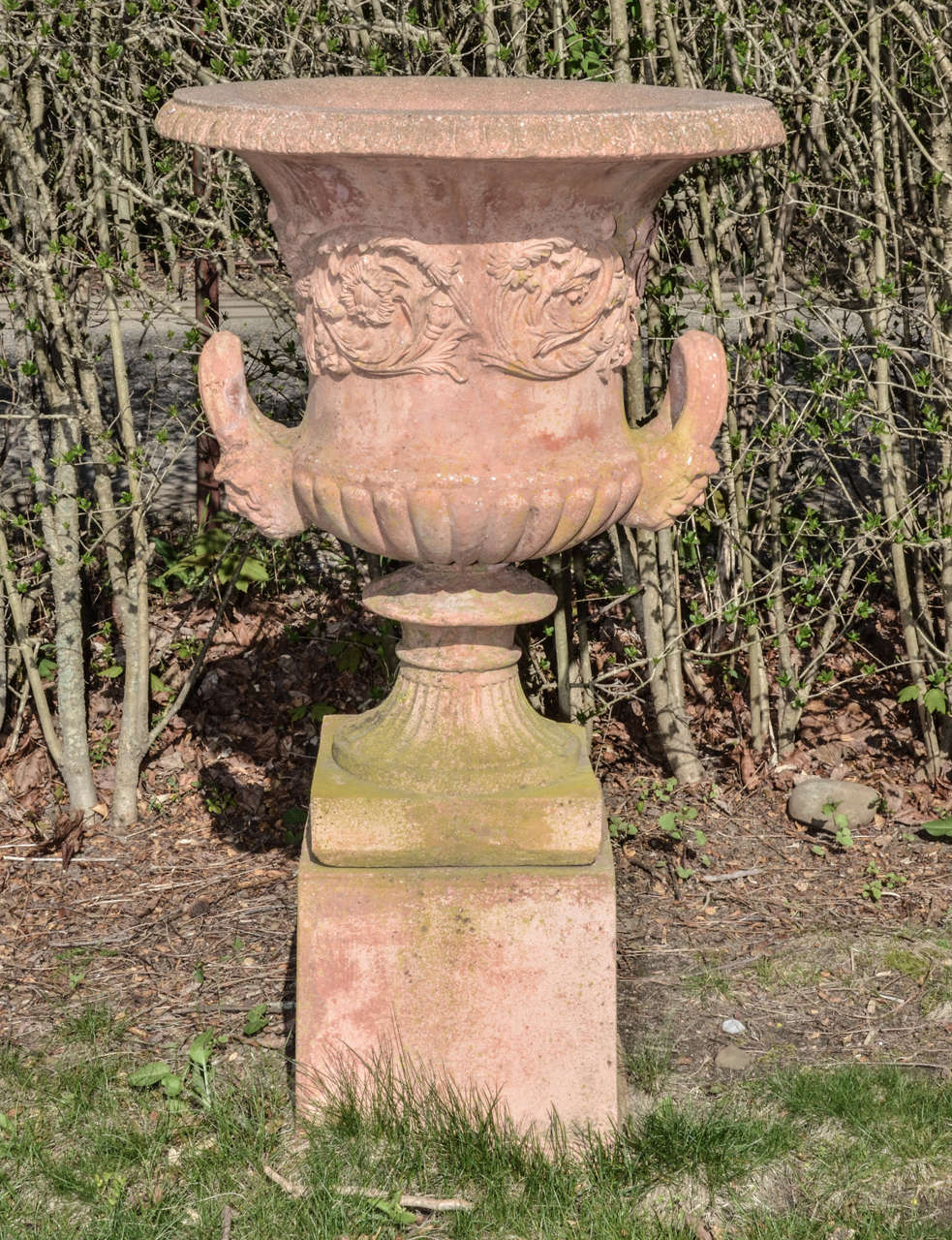 English Terra Cotta Color Cast Stone Neo Classical Style Urns On Pedestals. The Urns Are Impressive Size And Great Weathered Patina. Very Heavy And Completely Frost Proof. The Handles  Terminate In Human Mask-- The Top Third Of Urn Is Encircled With