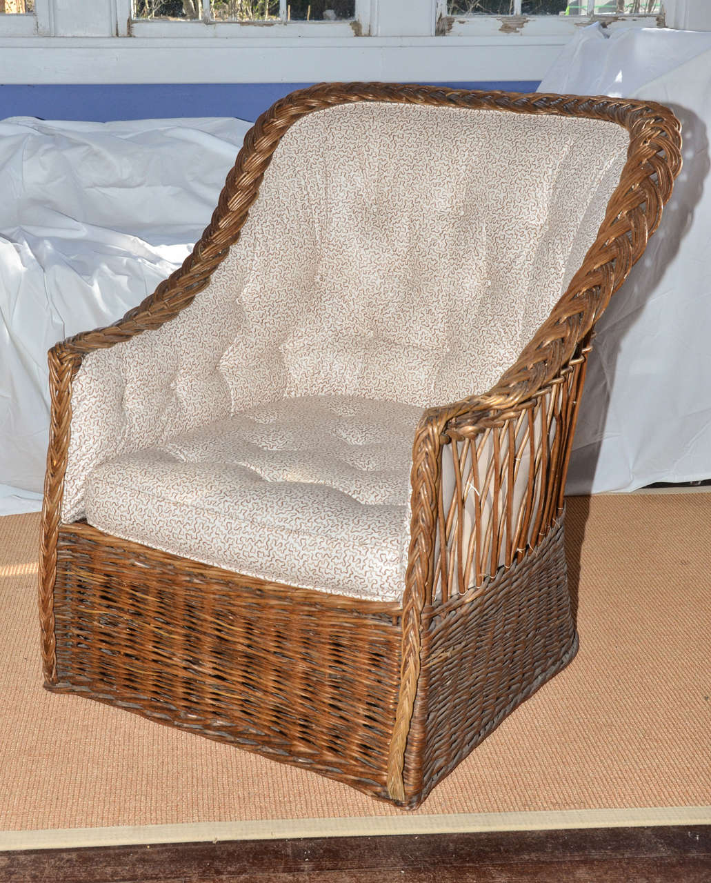 English natural wicker tufted back upholstered tub chair. The top of the arms have braided pattern; the back is backed with a lattice pattern. The tub shaped back has tufted upholstery in a brown and cream coral pattern, (same as Item #1405089201329