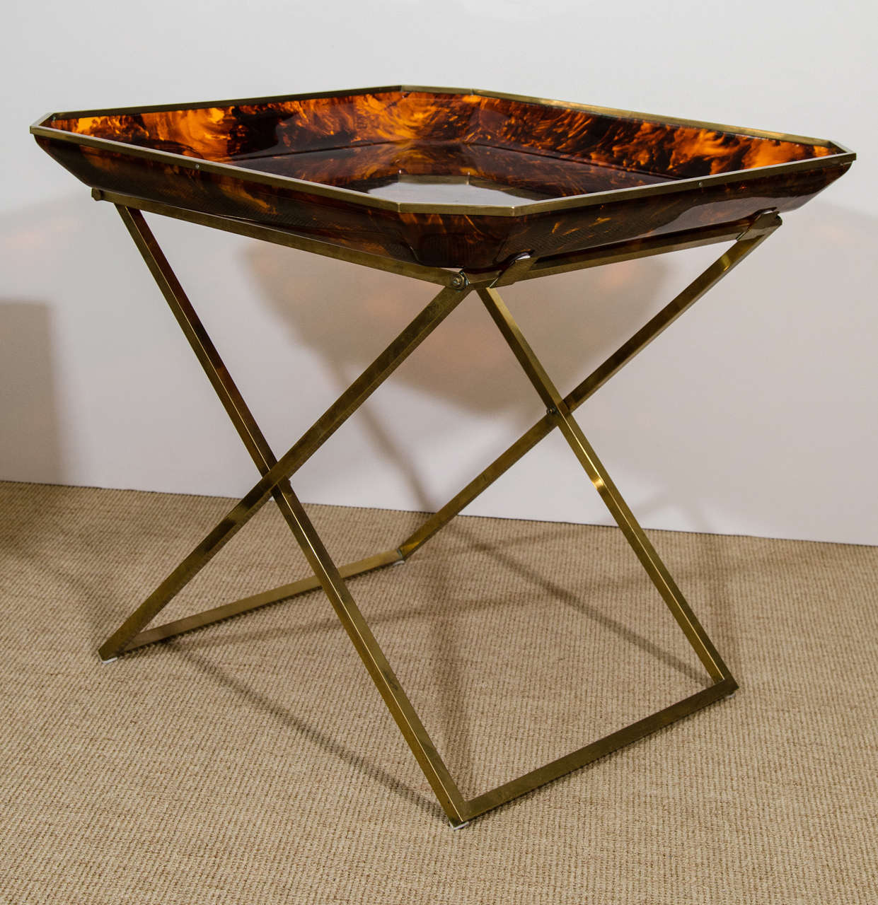 Tortoise plexiglass tray table with a brass "X" base.

Designed by Monique Roger and Vincent Jacquard of 'Archea-Milano', 1970. 

Sold at select boutiques in the 1970s: Christian Dior, Ave. Montaigne, David Hicks, Paris, and Khazen