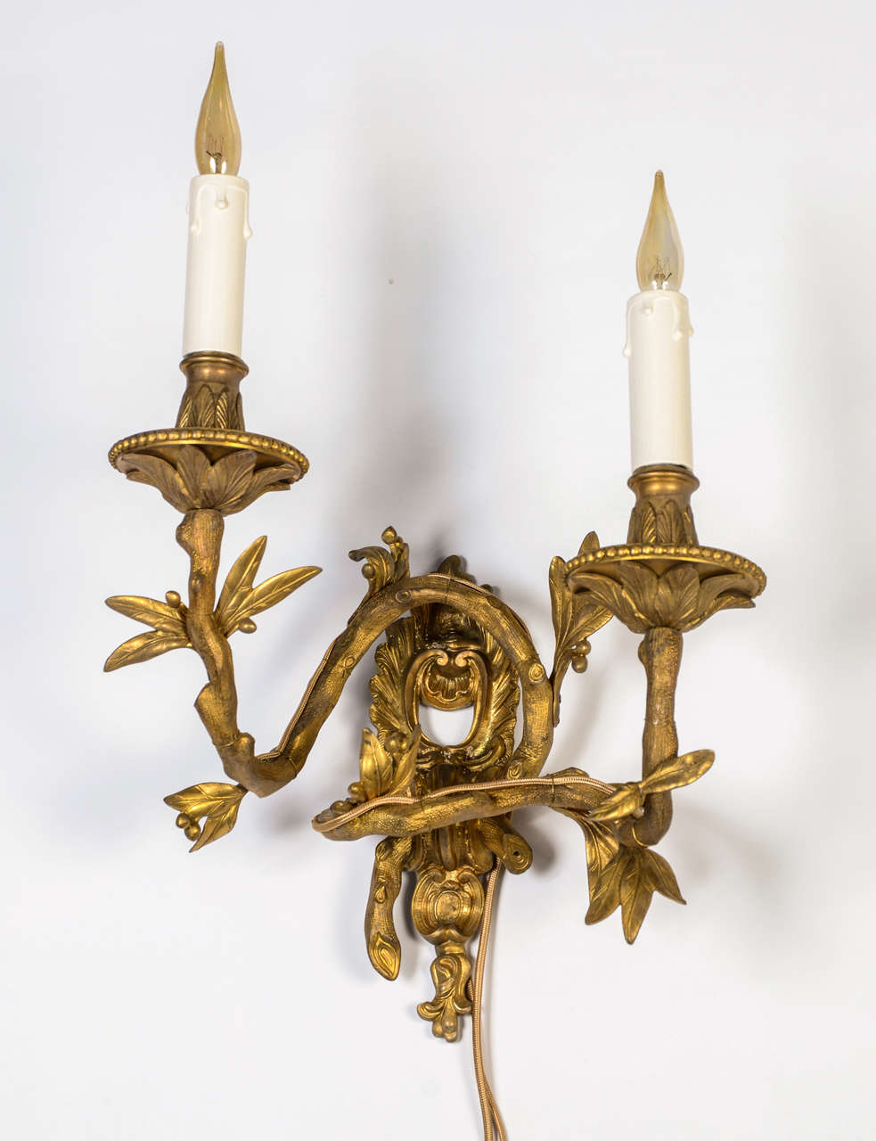 Set of four impeccable bronze wall sconces made in the 19th century, original patine, Louis XV style. The originality of this set lies in the imitation of tree branches by the arms of light completed by leaves and fruits.
New Electrification.