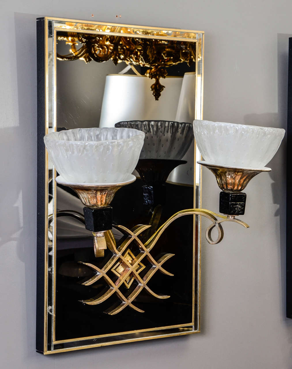 Very nice pair of art deco style wall sconces made of a big black mirror with brass frame and decorations, two arms finished by different Murano glass parts .
Originaly a set of four, only two are available (the two others have been sold).
New