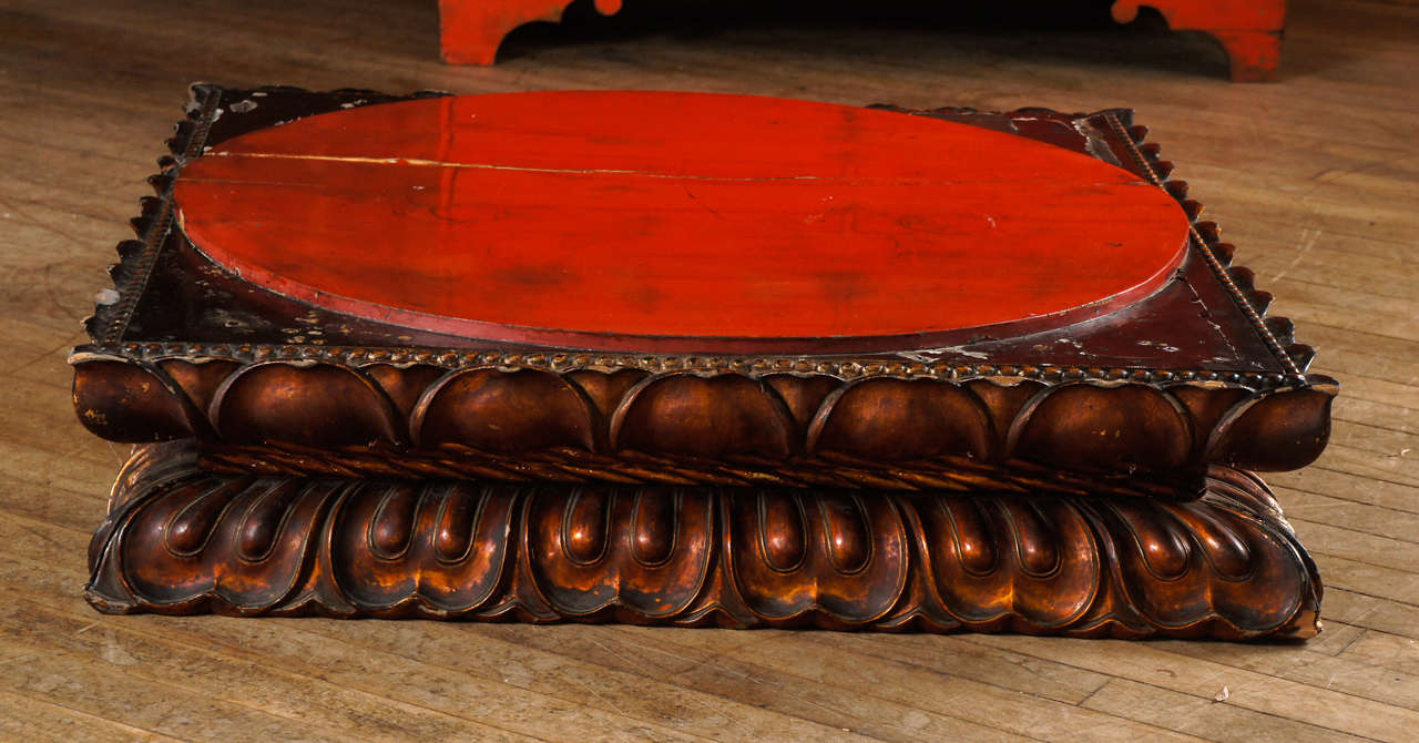 intense raised vermillion lacquered circle on a square platform with gadrooned trimmed edging