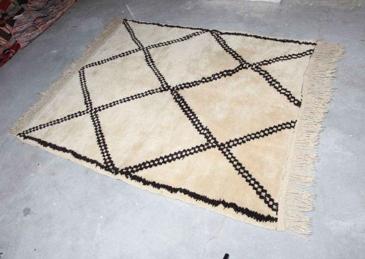 Vintage Beni Ourain rug from Morocco, C 1960. It is 100% wool and hand loomed. Deep wool pile in a light cream color with bold geometric pattern.
Size is 4'4