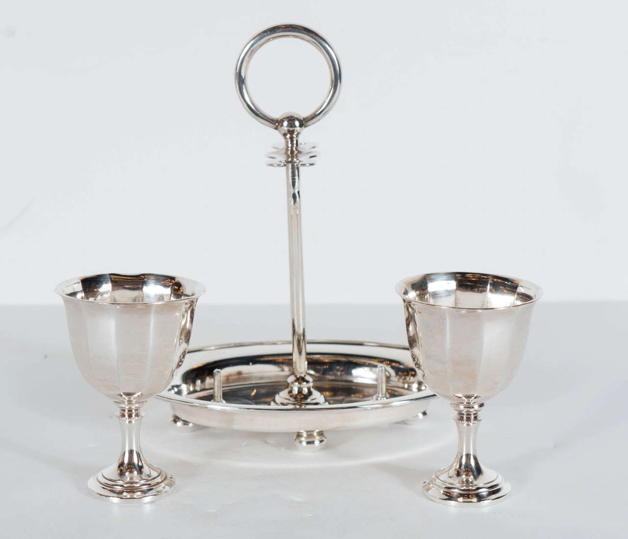 This  Art Deco 2 egg holder features a stylized holder fitted with a handle and tray . It is signed Daniel and Arter on the bottom.This is a very elegant piece from another time.
