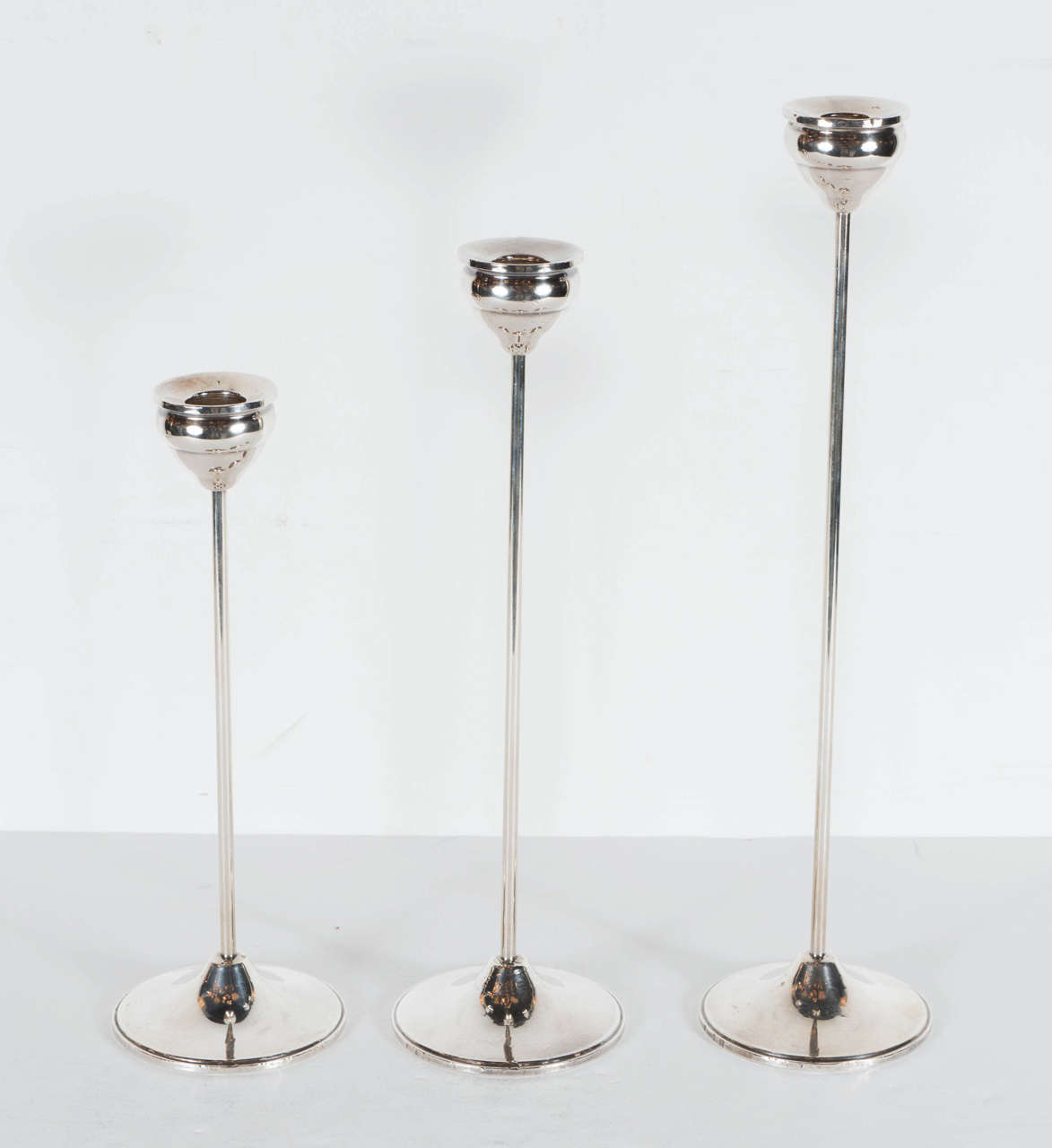 These candleholders feature a tapered columnar form with a stepped conical base with a tiered candle holder at the top. Great minimalist design and they are marked Sterling Duchin on the bottom