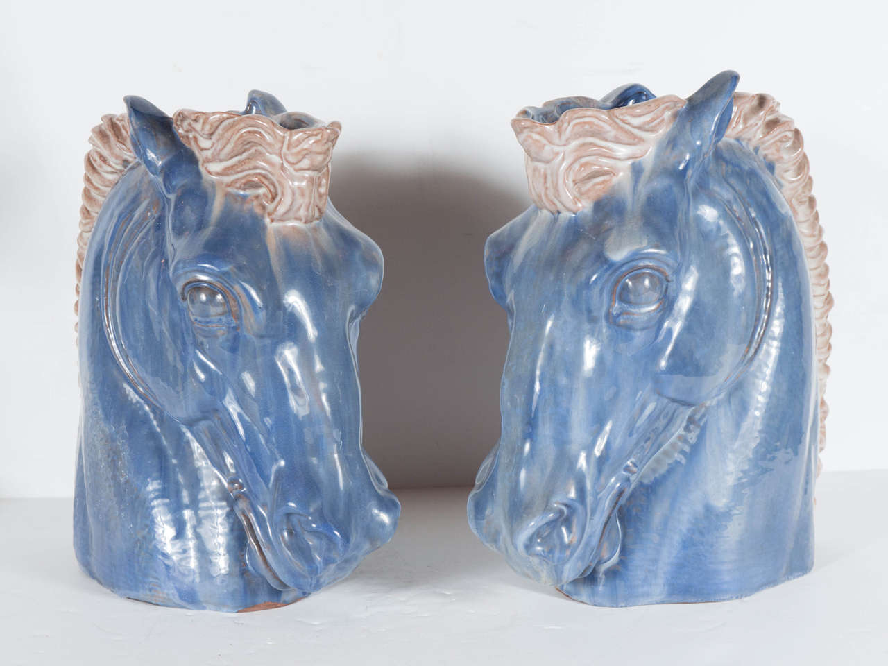 This gorgeous pair of 1940s hand-painted ceramic horse head vases by Stangl are exceptional. There craftsmanship is exquisite featuring a wonderful hue of sea blue with cream detailing. They have been hand-painted and feature a great stylized form