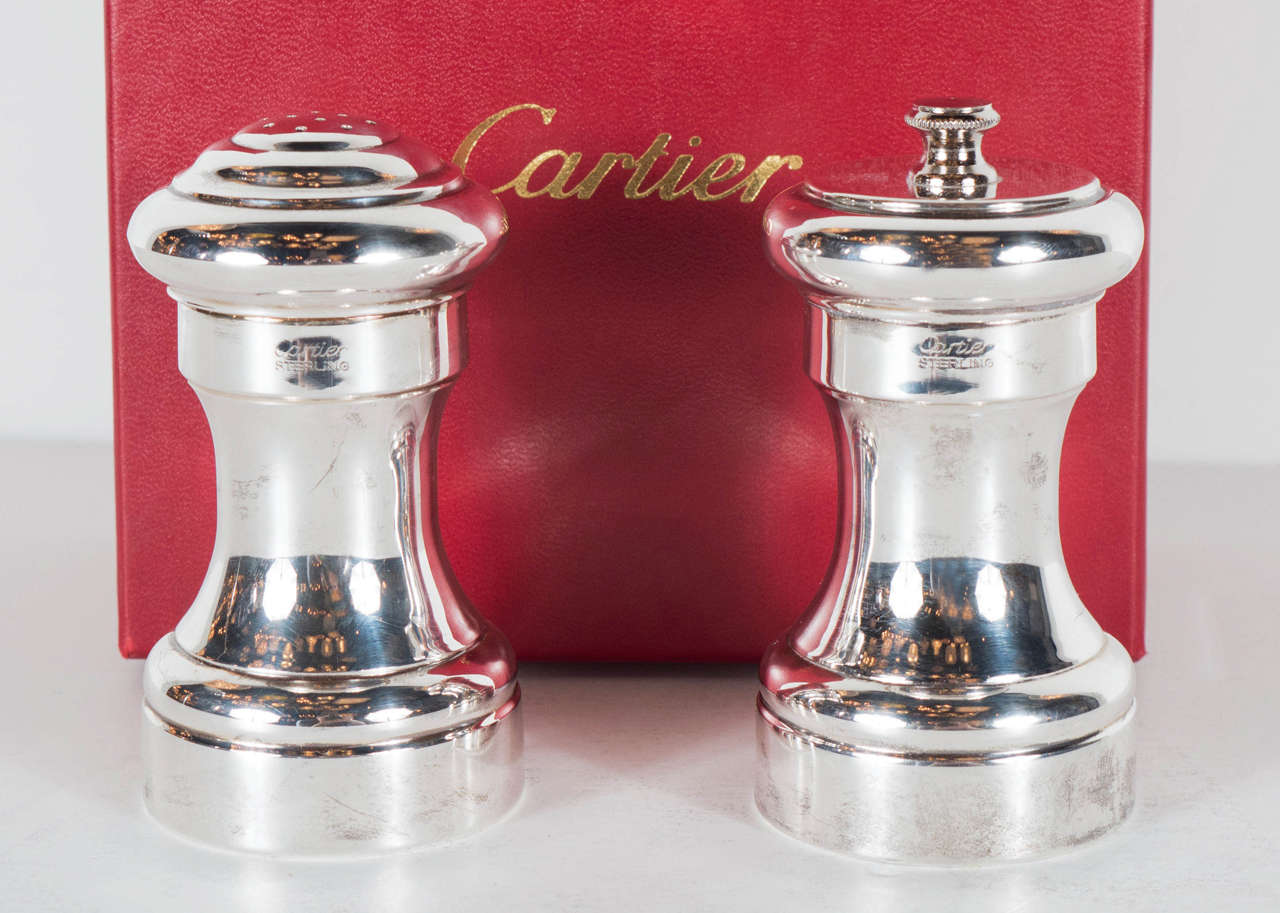 This stunning set features a salt Shaker and a pepper grinder both in sterling and signed Cartier as well. They have a streamline skyscraper style design .These are in mint condition and also have their original box.