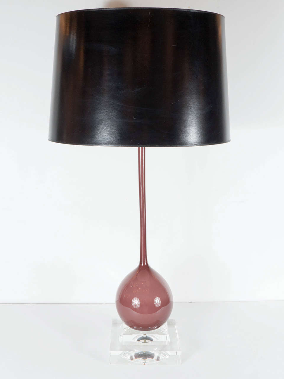 This exquisite Mid-Century Modernist table lamp features a tear drop body in handblown murano glass in a sophisticated mauve hue resting on stepped glass base. This lamp is in excellent condition and has been newly rewired and is fitted with a