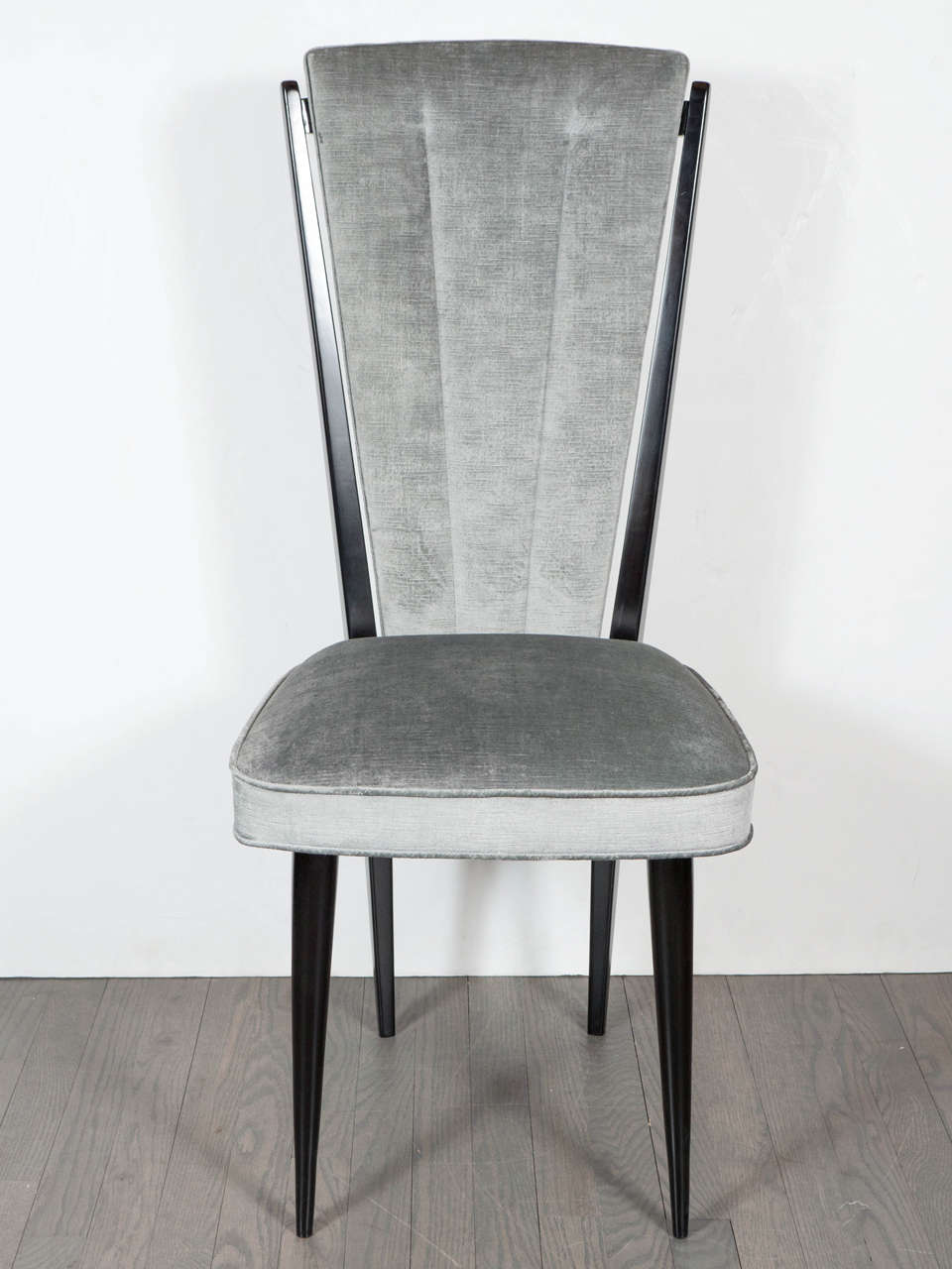 Exceptional set of four Mid-Century Modernist dining chairs in the manner of Gio Ponti with sculptural ebonized walnut frames and upholstered in a lux smoked pewter velvet. Each chair has an elongated upholstered back support that rests at a slight