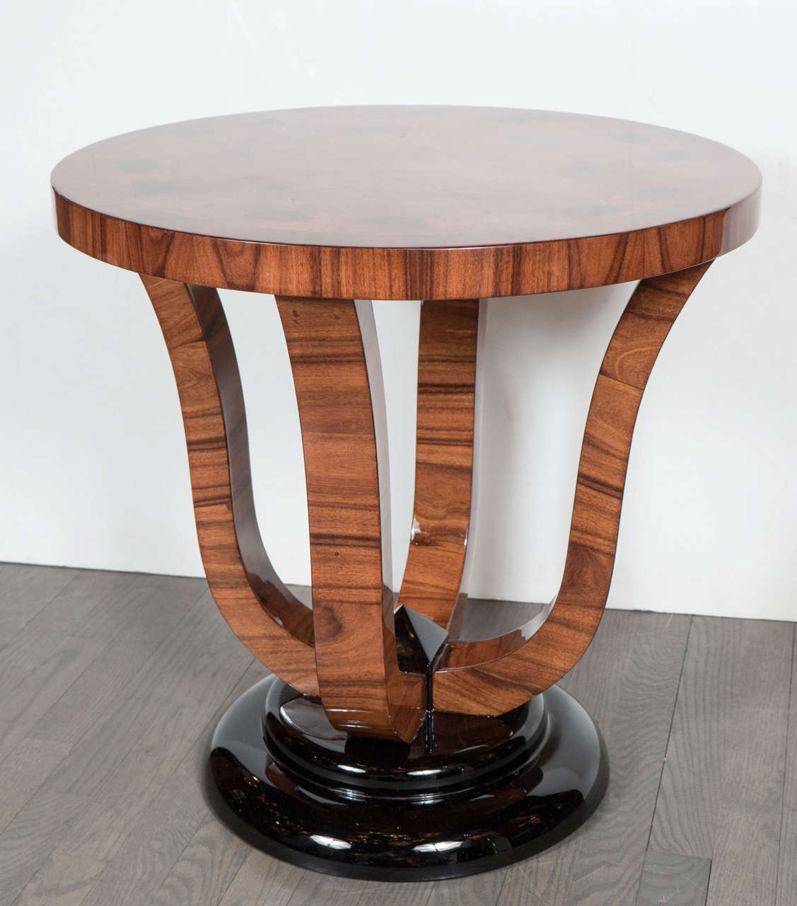 This incredible Art Deco gueridon table is truly exquisite. It features a beautiful design of book matched burled carpathian elm in a pie design with a surround of exotic walnut and supporting legs. It also features an Art Deco black lacquered