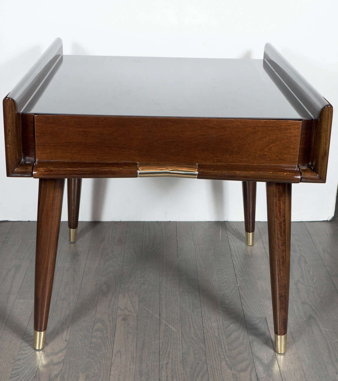 This very sophisticated pair of Mid-Century Modernist sculptural side tables are stunning! Designed in the manner of Gio Ponti, they feature the utmost quality and workmanship . Created in book-matched mahogany, it's symmetrical shape is structured