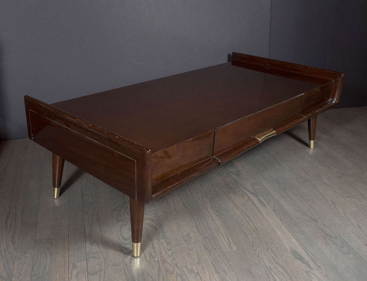 This Mid-Century Modernist sculptural cocktail table is ultra chic. Created in the manner of Gio Ponti, it features a  structured rectangle shape in book-matched mahogany. It is also a great and practical size for modern living.It is also fitted