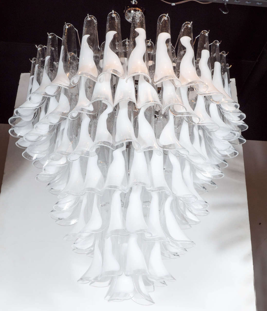 This stunning Modernist feather chandelier was handblown in Murano, Italy- the island off the coast of Venice renowned for centuries for its superlative glass production. Realized in the manner of Vistosi, the chandelier offers seven tiers of