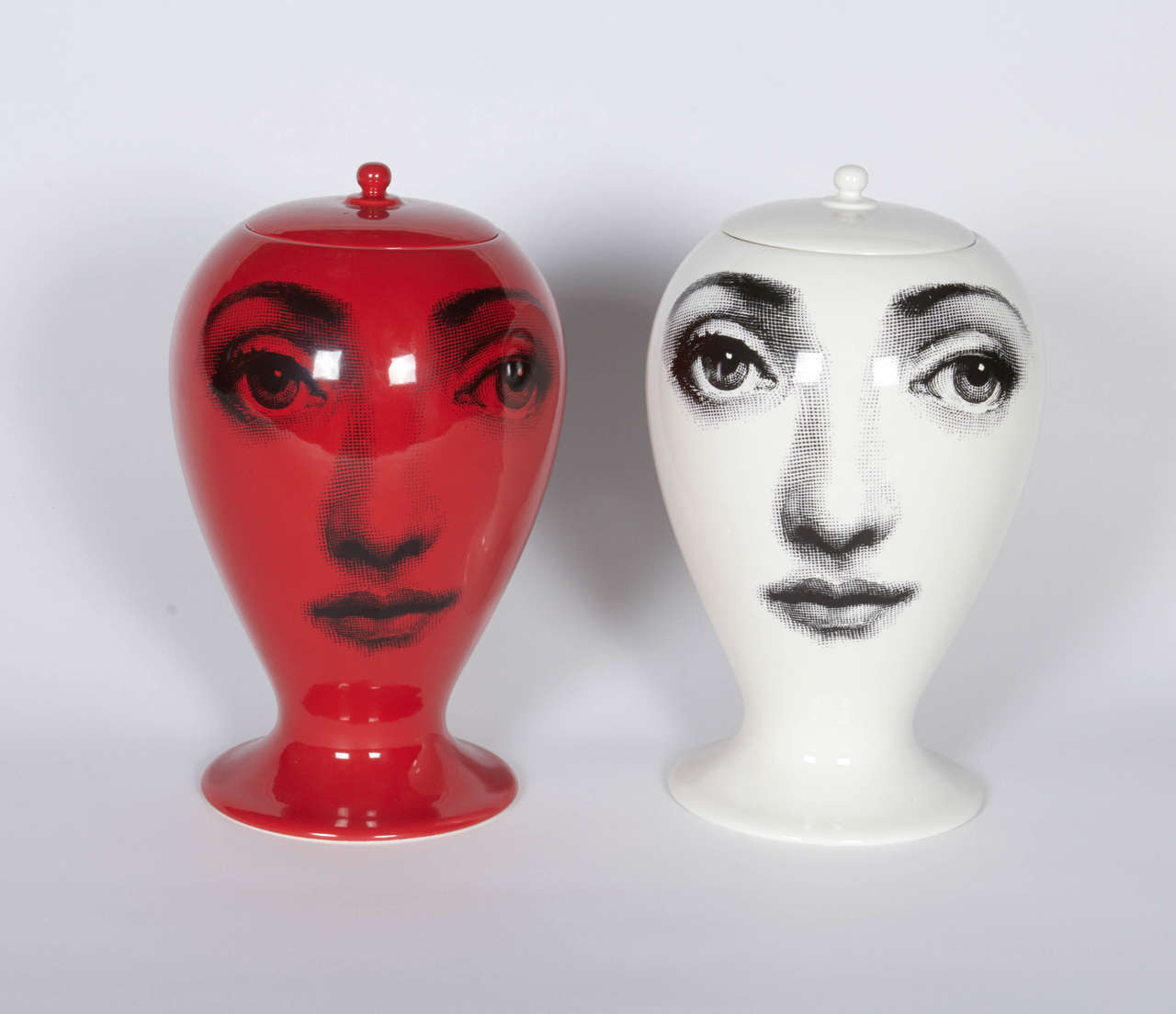 The pair of vases incorporates the face of soprano Lina Cavalieri whose face was featured more than 11,000 works of Piero Fornasetti. The facial features slightly distorted on the convex surface presents the whimsical nature of Fornasetti's oeuvre.