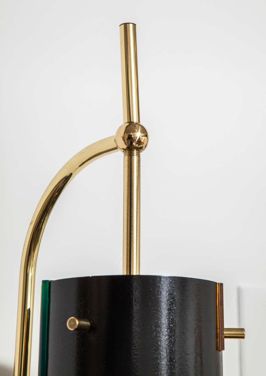 Pair of Mid-Century Italian sconces. 
This pair has been restored with new lacquer, polished brass and rewired.
Great combination and use of materials.
The black enamel is highlighted with beautifully inserted color strips.