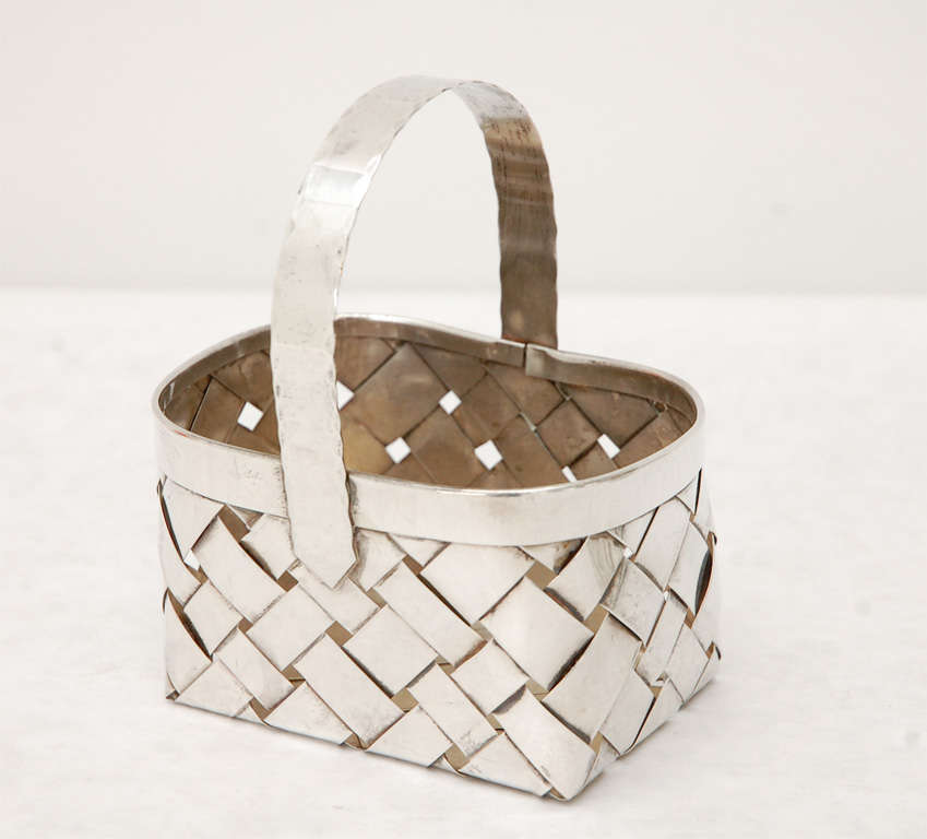 An enchanting handmade trio of woven sterling silver baskets with a hammered detail on the handle. Stamped Cartier. Dimensions provided are for the larger of the three baskets. The pair of smaller baskets measure 3