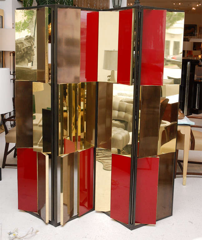 A glamorous fixed panel folding screen custom made for a Las Vegas Gucci boutique features swiveling panels in brass backed with either red or wood lacquered panels to change up the appearance of the screen. The panels are assembled to 45 degree