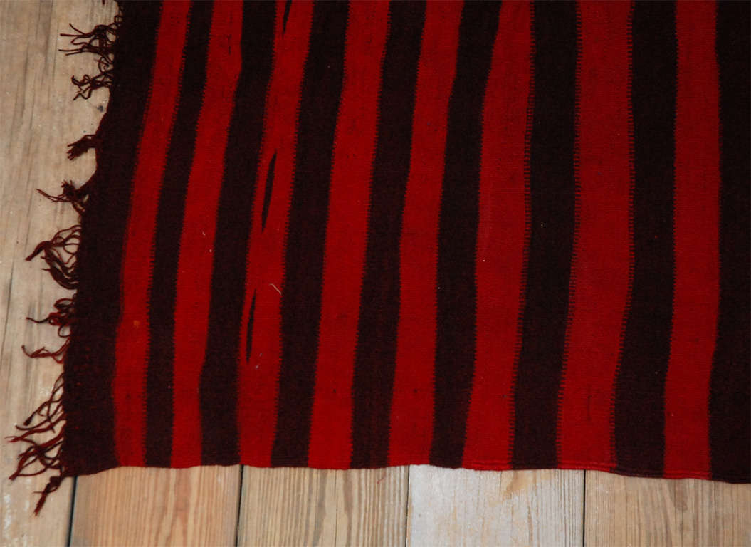 Traditional Moroccan Kilim in wine and red alternating stripes.