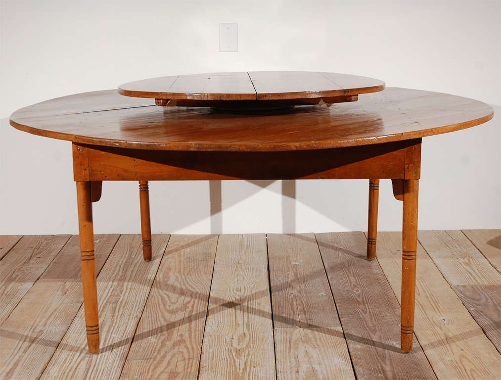 Warm honey colored Pine farmhouse style table with a Lazy Susan and notched legs.