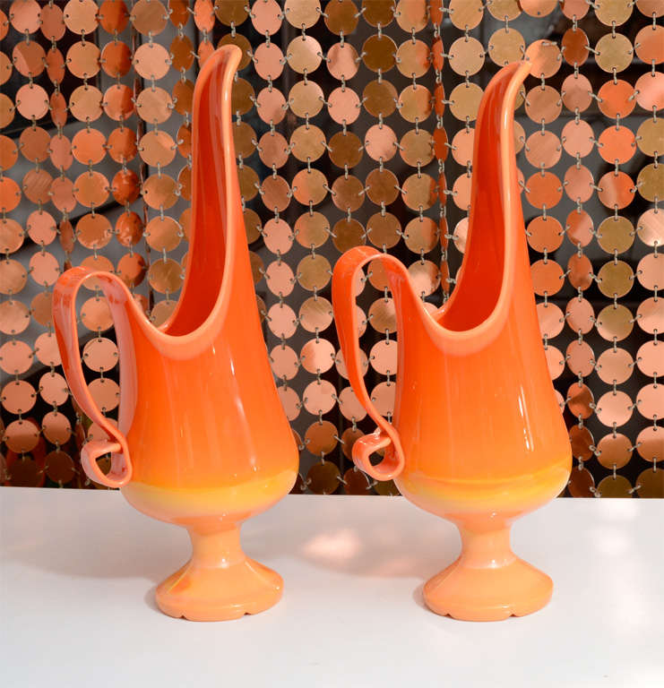 Graceful, matching pair of ewers by L.E. Smith for Fayette Glass. These are in the classic Bittersweet Orange color, and are described by the company's original literature as candle pitchers; each one has a place to insert a candle within.