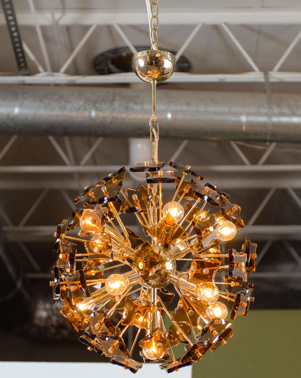1960's brass Sputnik style chandelier with 60 randomly faceted smoked glass pieces surrounding 11 light bulbs.