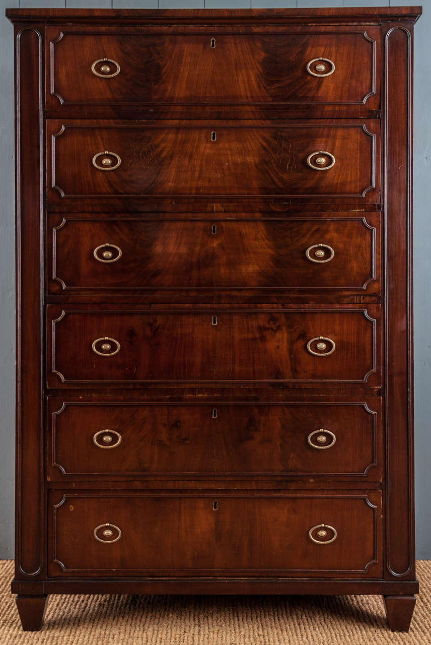 A restrained 19th century figured mahogany chest of six long drawers on original feet with elegant brass handles.