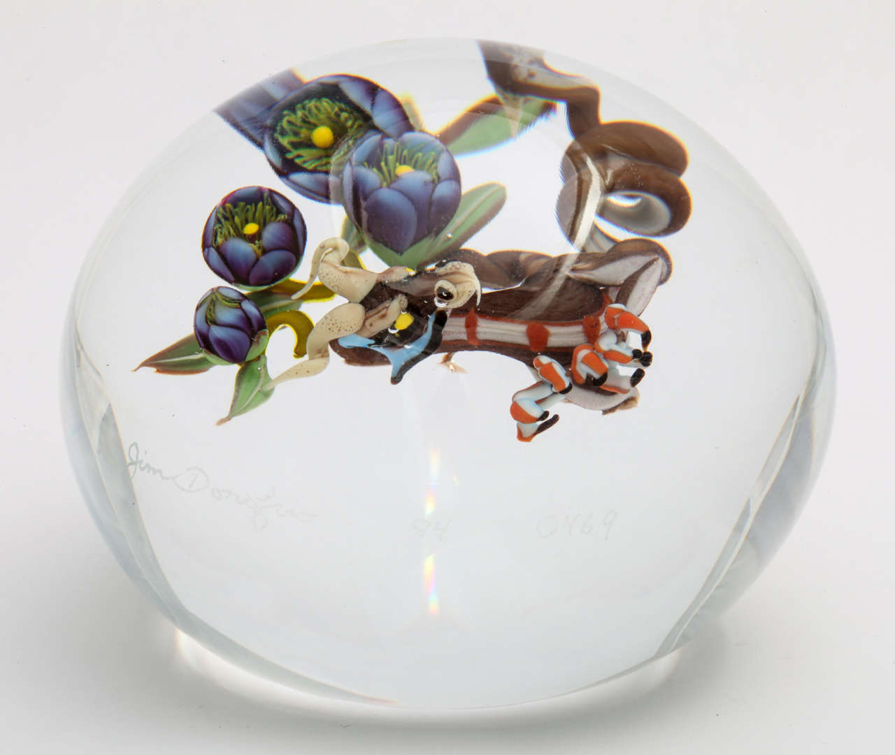 A Jim D'Onofrio dragon root paperweight with purple gentain flowers and a dragon root, signed Jim Donofrio, 94, 0469