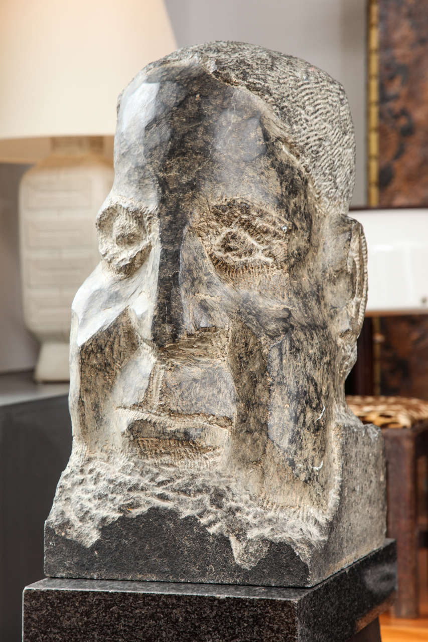A stone bust carved to reveal the strong characteristics of a human head, we call him 
