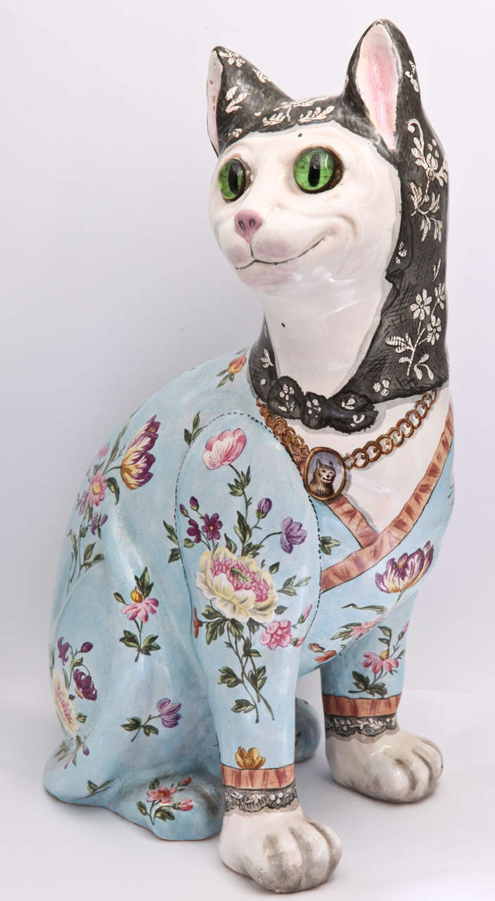 A fine unsigned Emile Galle faience cat decorated with a powder blue ground and painted with bouquets of flowers, medallion of dog around neck, glass eyes