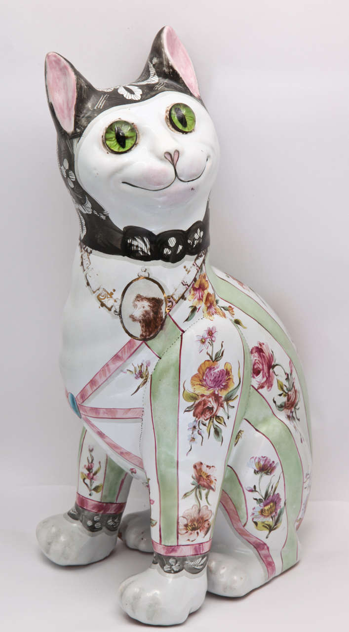 A fine unsigned Emile Galle faience cat decorated  with green stripes and flowers, medallion of dog around neck, glass eyes