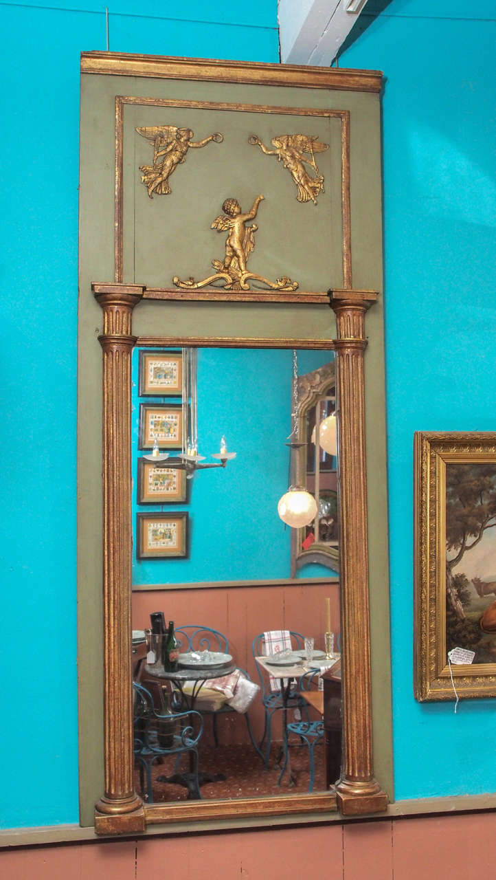 Early 19th century French Empire period painted and gilded mirror with pilaster decoration and cherub relief, circa 1810.