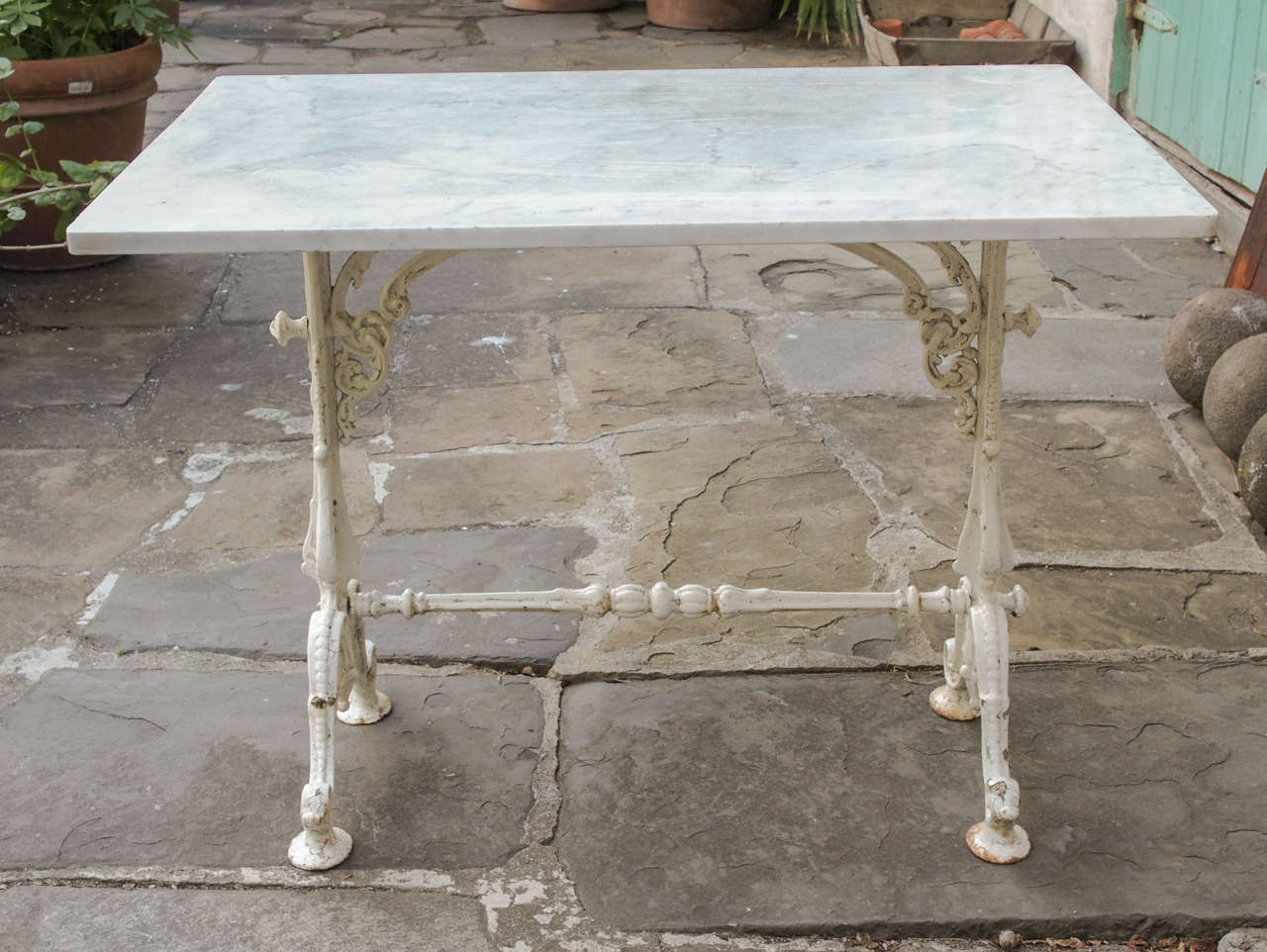 French Napoleon III period cast iron garden table with exuberant base and white marble top.