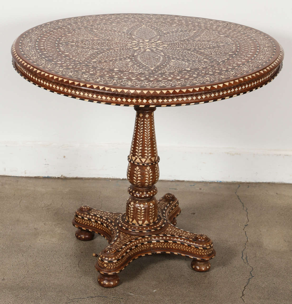 Rare large 19th century Anglo Indian extensively rosewood inlaid with bone round table with finely turned stem and legs. The heavily well detailed bone inlay covers both the top and stem, as well as the legs. Could be used as a center table or small