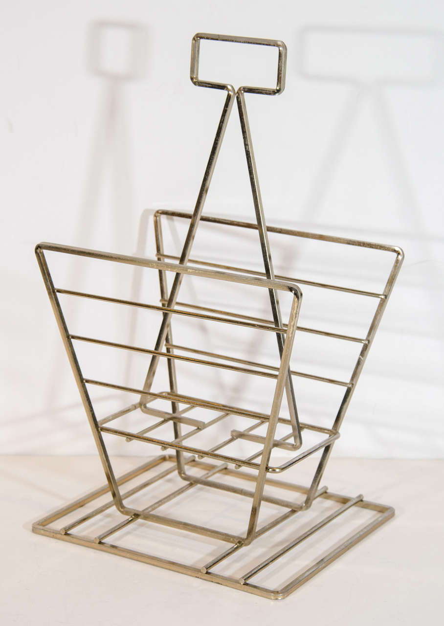 Architectural magazine or book holder with Art Deco inspired design. The stand has a geometric form in patinated brass plate over steel. It features rectangular base and stylized handle.
