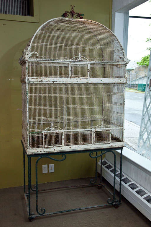 A large white painted bird cage on a metal stand