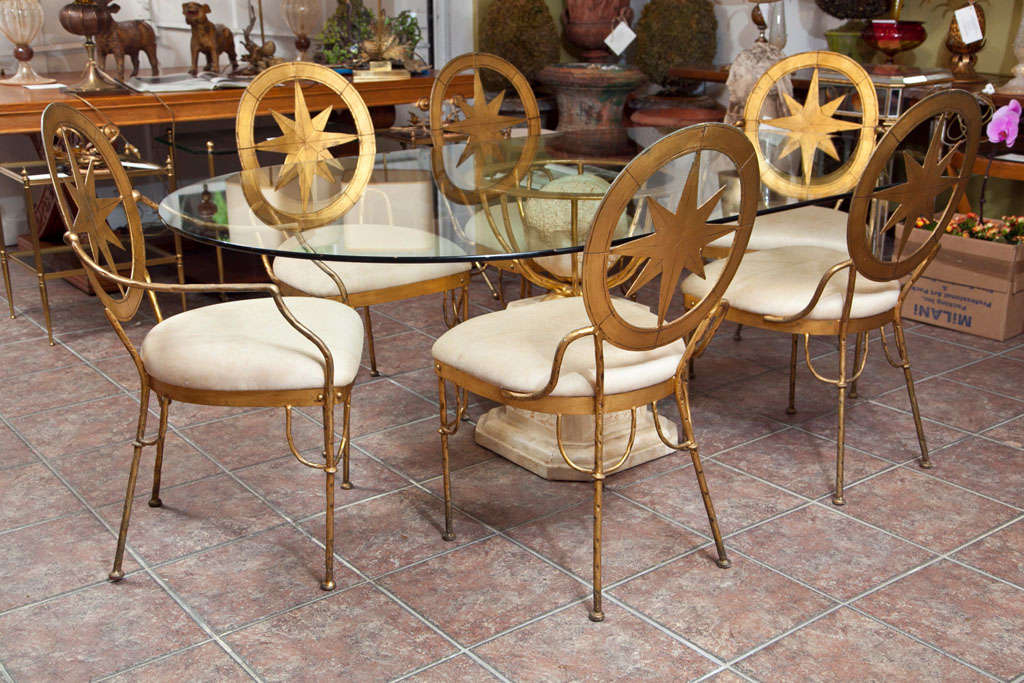 Marble, sculpted stone & glass top table with gilded wrought iron chairs in the manner of 