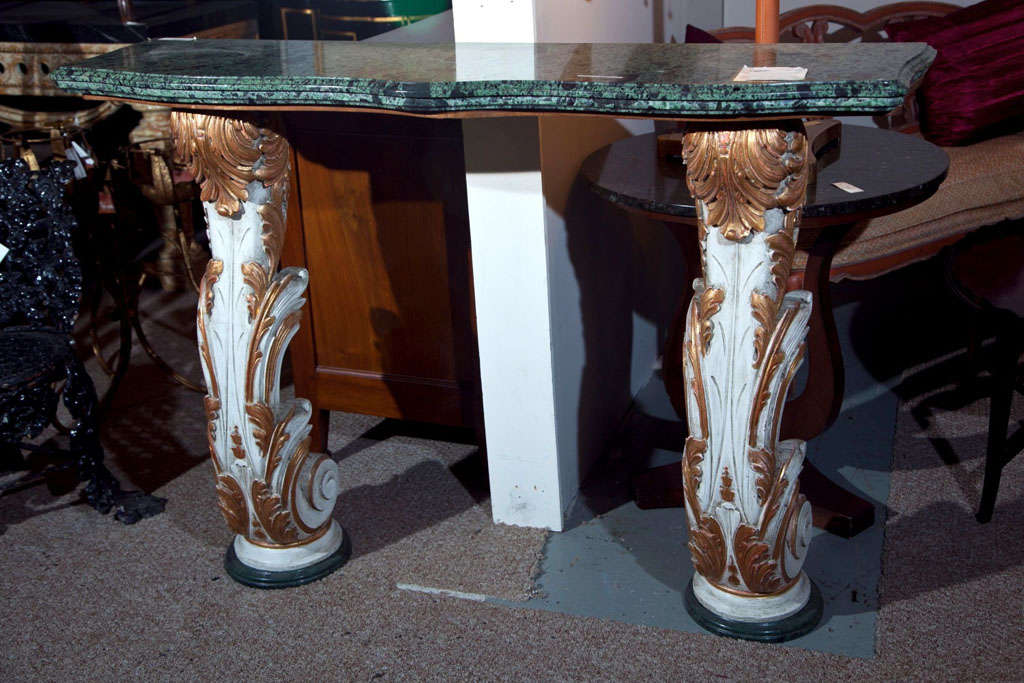 A parcel paint and gilt decorated marble-top console by Maison Jansen. The marble base supporting a paint decorated column sitting under a Malikite green marble top.